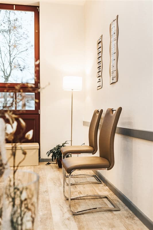 Heller Eingangsbereich mit Stehlampe und Sitzgelegenheiten am Fenster